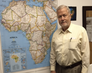 Mark Wentling standing by map of Africa