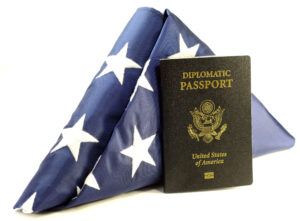 Diplomatic passport leaning against a folded American flag 